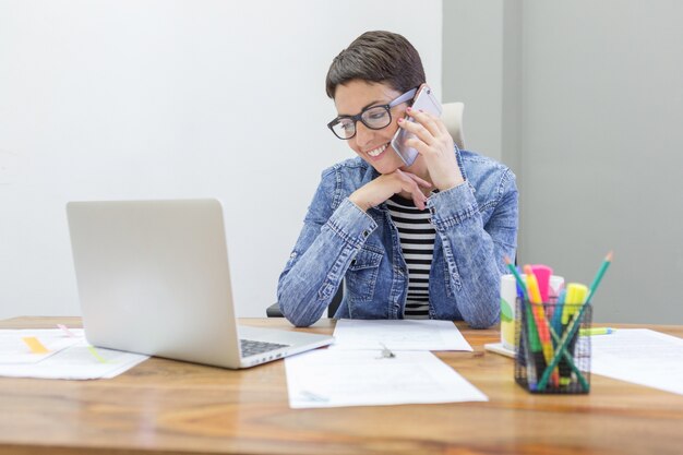 Fröhlich Mitarbeiter am Telefon zu sprechen