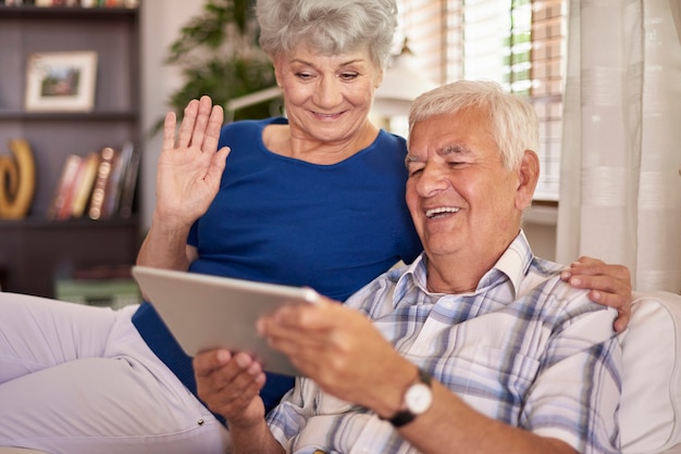 Fröhliche ältere Ehe mit ihrem digitalen Tablet