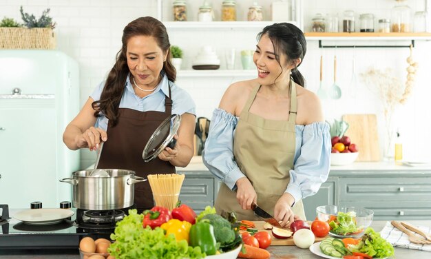 Fröhliche asiatische Familie, die zu Hause in der Küche Essen zubereitet Genießen Sie Familienaktivitäten zusammen