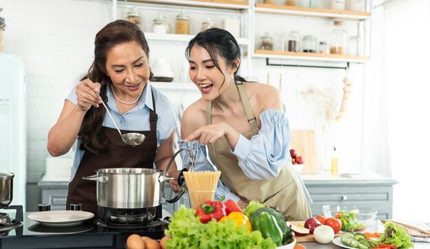 Fröhliche asiatische Familie, die zu Hause in der Küche kocht Genießen Sie Familienaktivitäten zusammen