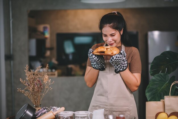 Fröhliche asiatische Frau, die zu Hause hausgemachte Bäckerei kocht Starten Sie ein KMU-Konzept für kleine Unternehmen