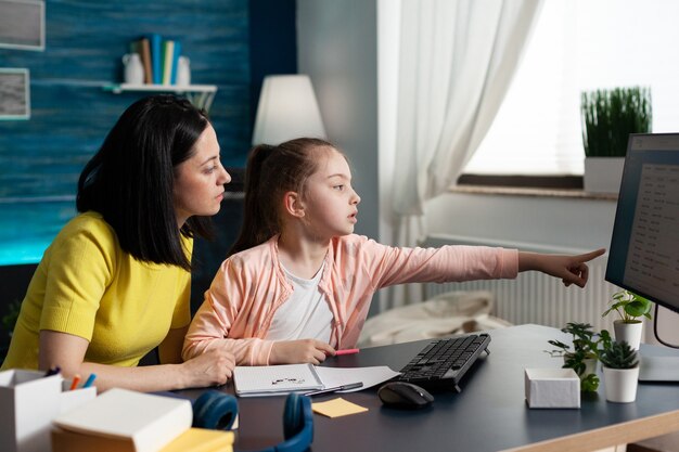 Fröhliche Eltern, die neben ihrer Tochter sitzen und gemeinsam Hausaufgaben machen