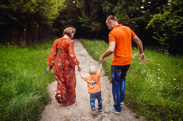 Fröhliche Familie geht den Weg entlang