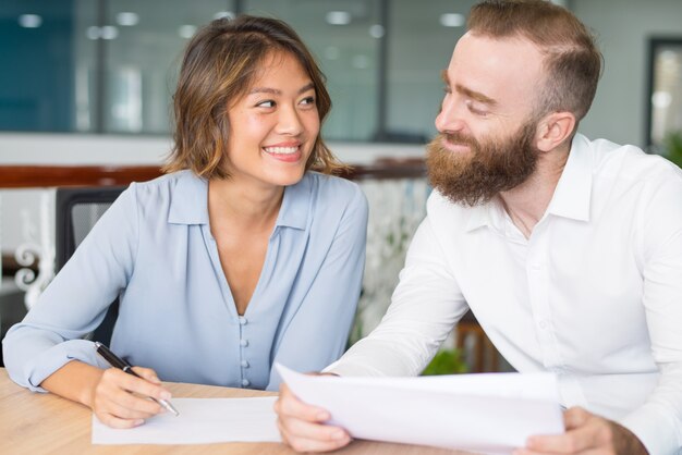 Fröhliche flirtende und scherzende Büroangestellte