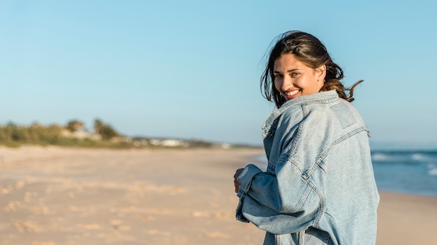 Fröhliche Frau am Strand über die Schulter schauen