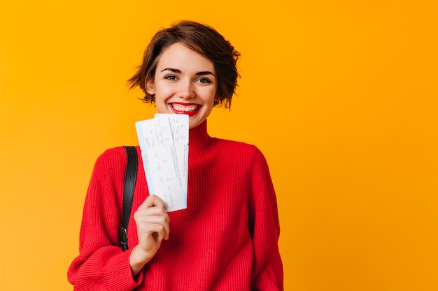 Fröhliche Frau mit kurzen Haaren, die Tickets hält