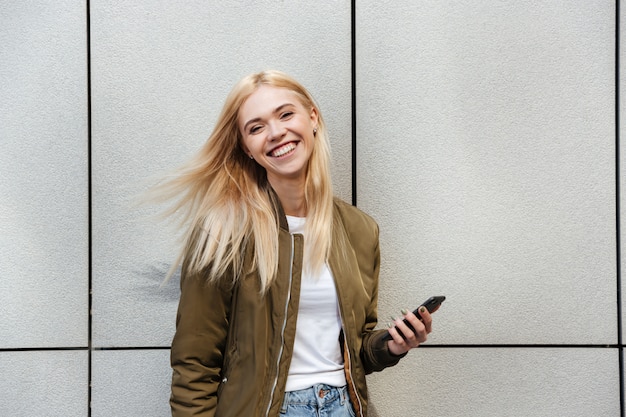 Fröhliche Frau mit Smartphone lachend