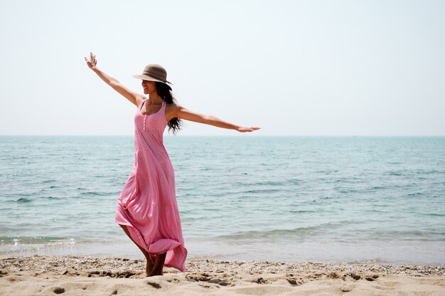 Fröhliche Frau tanzen am Strand