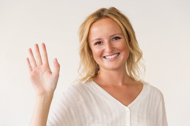 Fröhliche Frau winkt Hand