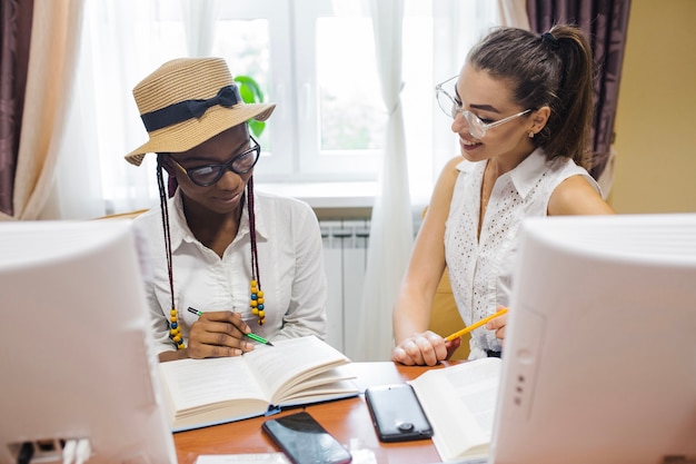 Fröhliche Frauen arbeiten mit Buch