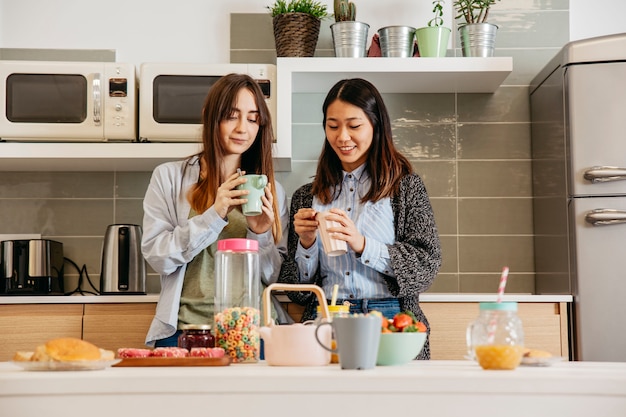 Fröhliche Frauen, die zusammen frühstücken