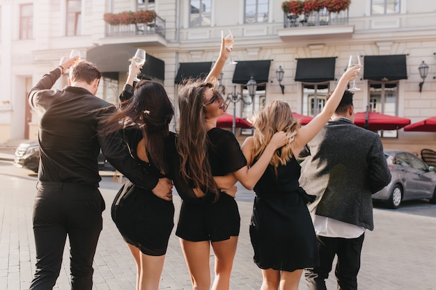 Fröhliche Freunde, die Champagner auf der Party im Freien trinken