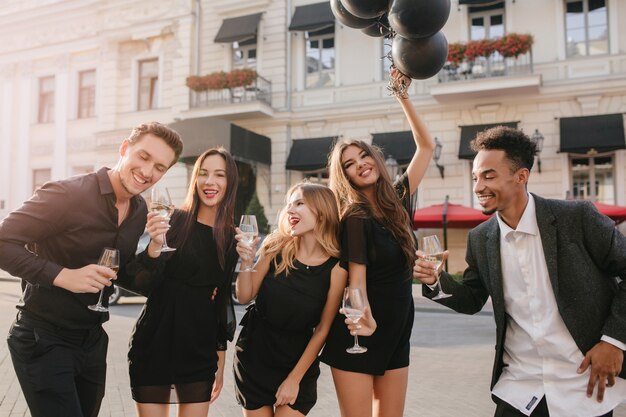 Fröhliche Freunde, die Champagner auf der Party im Freien trinken