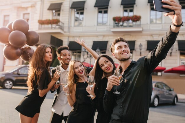 Fröhliche Freunde mit großem Lächeln machen Foto während der Feier