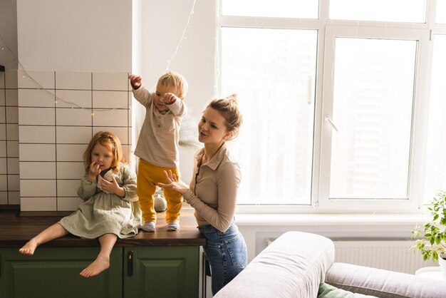 Fröhliche, freundliche Familie von junger Mutter, Tochter und Sohn im Alter von 23 Jahren verbringen Zeit zusammen an den Wochenenden zu Hause Lifestyle-Konzept