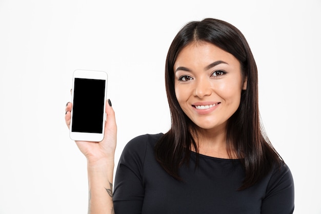 Fröhliche junge asiatische Frau, die Anzeige des Handys zeigt