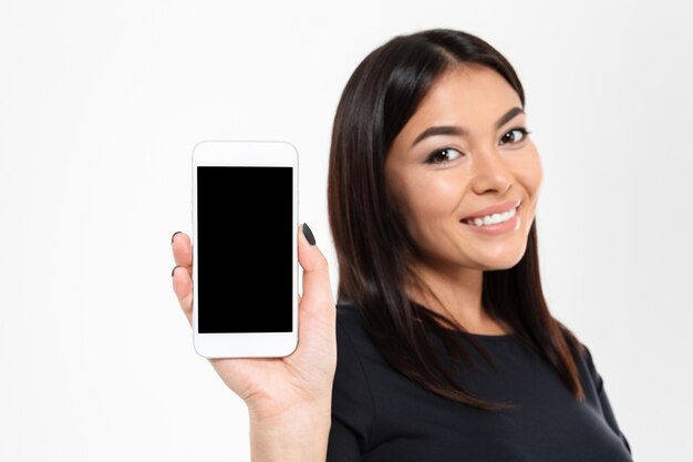 Fröhliche junge asiatische Frau, die Anzeige des Handys zeigt