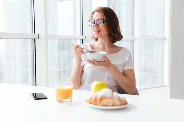 Fröhliche junge Frau, die Cornflakes isst