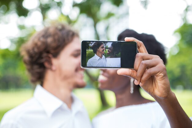 Fröhliche junge Mix-Rennpaar, die Selfie nehmen