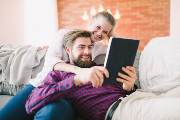 Fröhliche junge Paar mit Tablet