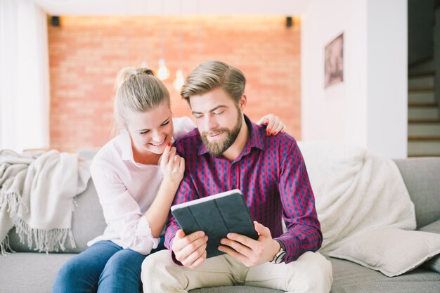 Fröhliche junge Paar mit Tablet