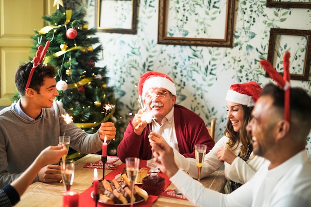 Fröhliche Menschen mit Bengalischen Feuer am festlichen Tisch