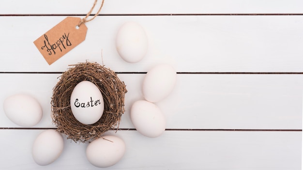 Fröhliche ostern-aufschrift auf ei im nest