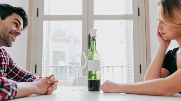 Fröhliche Paare bei Tisch mit Wein