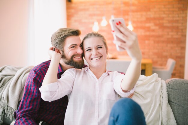 Fröhliche Paare, die selfie nehmen