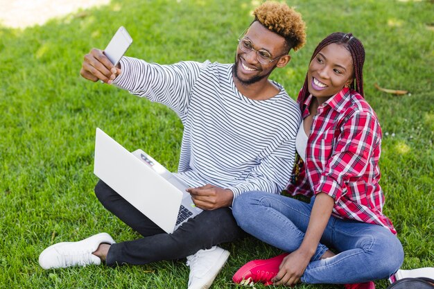 Fröhliche Studenten nehmen selfie mit Laptop