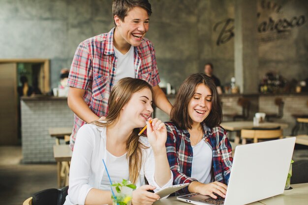 Fröhliche Studenten posieren mit Laptop