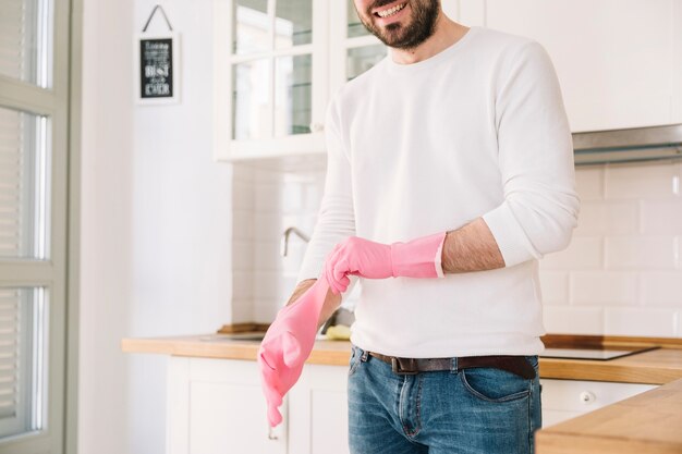 Fröhlicher Ernte Mann in Gummihandschuhen