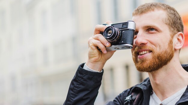 Fröhlicher hübscher Fotograf