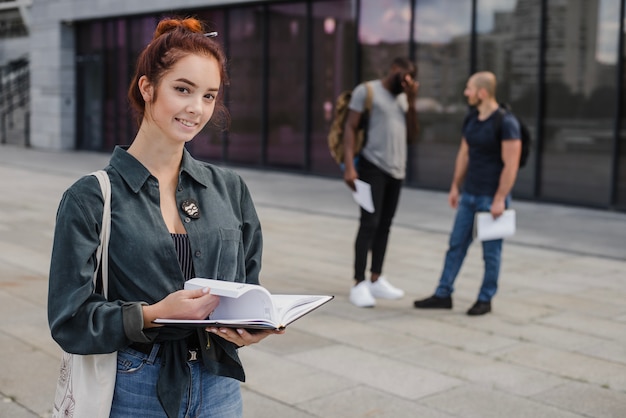 Kostenloses Foto fröhlicher junger student mit buch