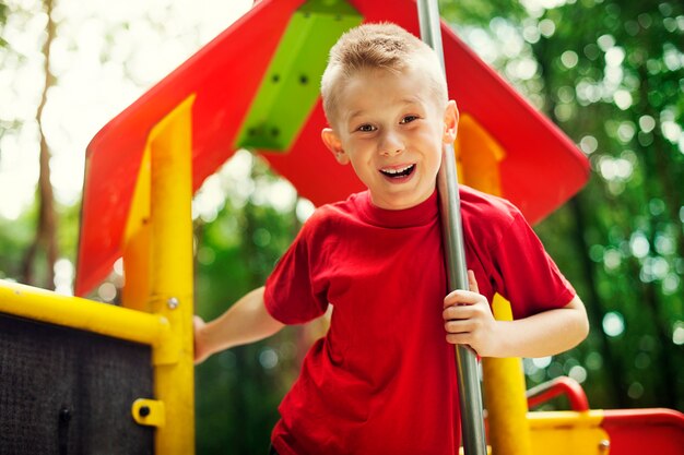 Fröhlicher kleiner Junge auf Spielplatz