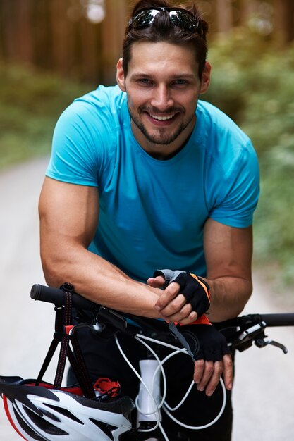 Fröhlicher Radfahrer, der zu Atem kommt