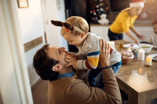 Fröhlicher Vater, der sich an Weihnachten mit seinem Sohn zu Hause amüsiert