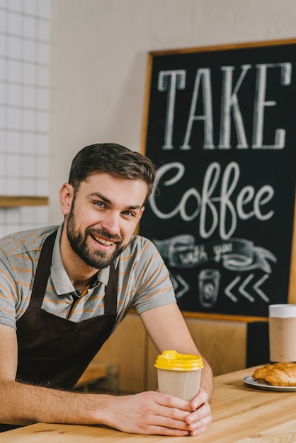 Kostenloses Foto fröhliches barista mit heißem getränk