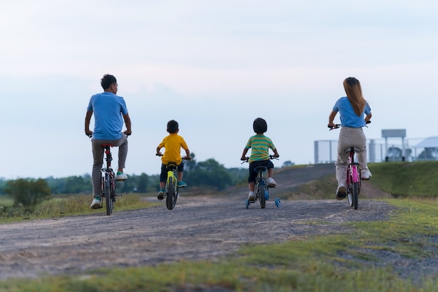 Fröhliches familienradfahren auf fahrrädern im freien, aktive eltern mit kindern haben spaß, familiensport und fitness, urlaub, entspannung im grünen