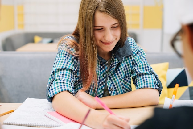 Fröhliches junges Mädchen im Klassenzimmer