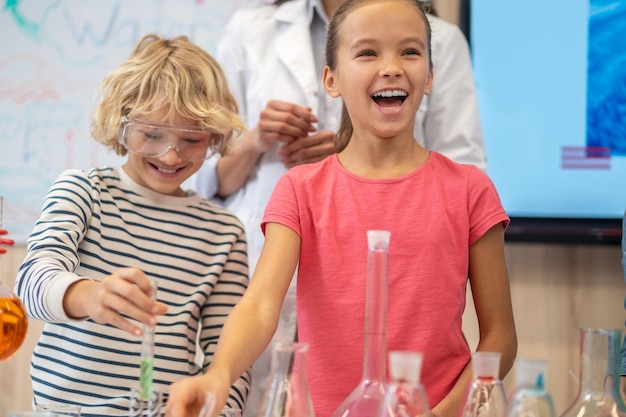 Fröhliches Mädchen am Tisch im Chemieunterricht