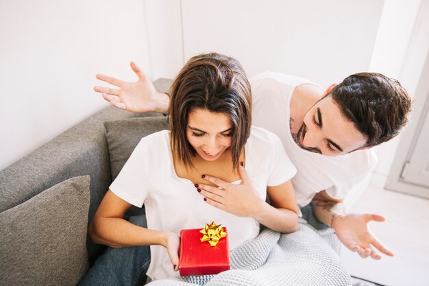 Frohe Frau, die Geschenk vom Mann empfängt