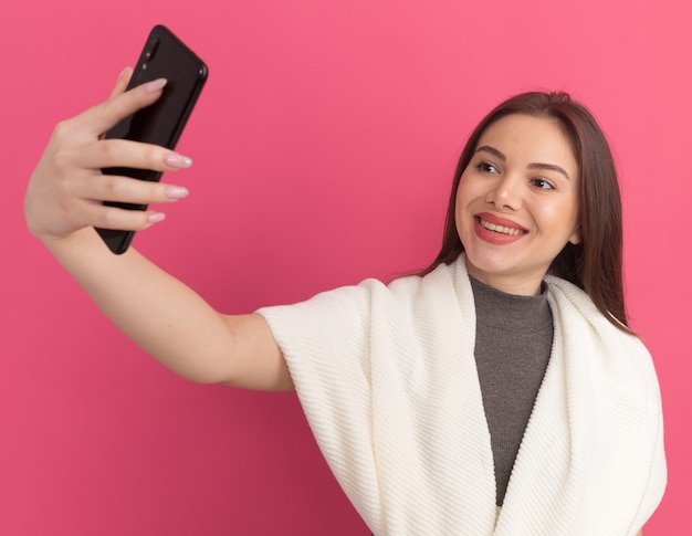 Frohe junge hübsche Frau, die selfie macht