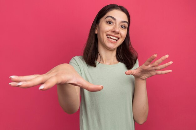 Frohe junge hübsche kaukasische Frau, die Hand in der Luft hält