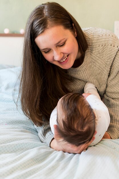 Frohe Mutter, die Baby in den Armen hält