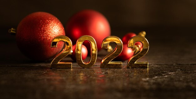 Frohes neues jahr 2022 highlight goldene zahlen schwarzer holzhintergrund rote kugeln und dekorationen celebra