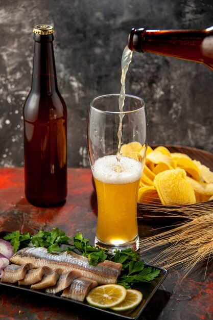 Frontansicht Flasche Bär, die mit Cips und Fisch auf hellem Hintergrund in das Glas gießt