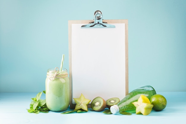 Kostenloses Foto frucht und smoothie mit leerem klemmbrett copyspace