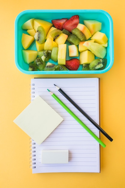 Fruchtsalat, der nahe Briefpapier liegt