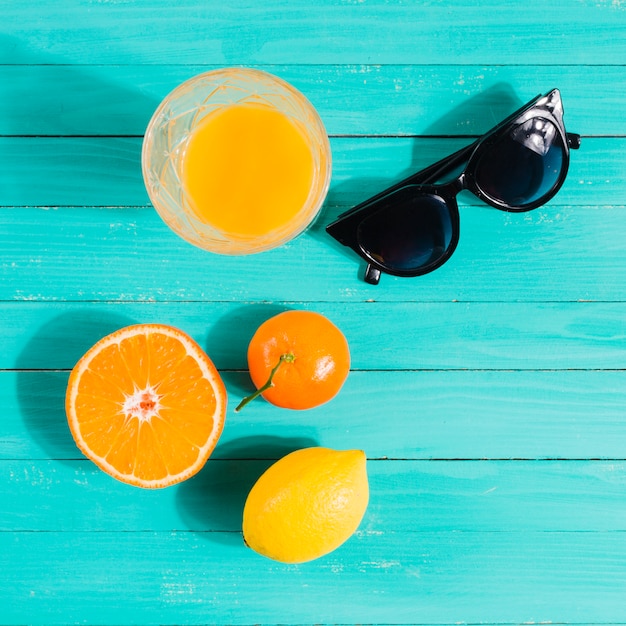 Früchte, Saftglas und Sonnenbrillen auf dem Tisch